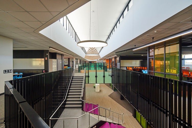 Interior shot showing multi-level view of the open modern learning street with staircases and coloured glass classroom windows