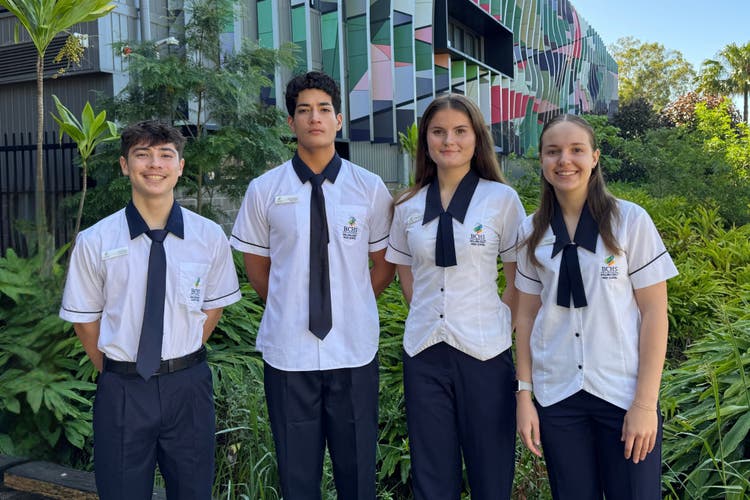 Two male and two female school captains standing in front of school